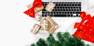 Hediyeli dizüstü bilgisayar, kırmızı şapka, Noel ağacı ve beyaz arka planda paketleme kutuları, üst görünüm, dağıtım konsepti.