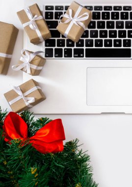 Hediyeli dizüstü bilgisayar, kırmızı şapka, Noel ağacı ve beyaz arka planda paketleme kutuları, üst görünüm, dağıtım konsepti.