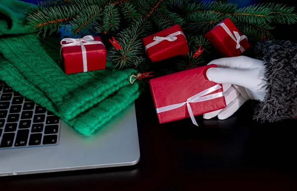 Mão Papai Noel Detém Presente Fundo Preto Com Laptop Árvore — Fotografia de Stock