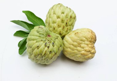 Taze yeşil kremalı elma, elma şekeri, anona cherimola (annona squamosa l.) beyaz arka planda yalıtılmış yapraklarla ikiye bölünmüş meyve. Tropikal egzotik meyve ve sağlıklı meyve