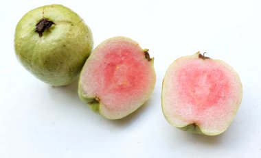 tatlı olgun pembe guava, kırmızı guava (psidyum guajava) yeşil yapraklı ve yarım dilimli meyve, beyaz zemin üzerinde tamamen izole edilmiş, üst görünüm, düz uzanmış, sağlıklı meyve kavramı