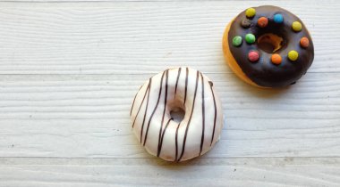 Taze donutlar çok renkli jöleli çikolatalar, renkli çörekler, tatlı renkli çörekler, çikolatalı vanilya kaplı kaplama ahşap masa arkaplanındaki izolasyon.