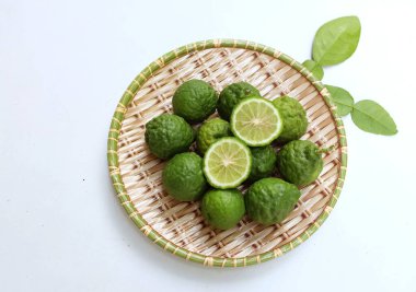 Çiğ kaffir limonu, bergamot, sülük limonu, mauritius papeda (citrus x hystrix l.) Bambuda beyaz bir sırt üstü., 