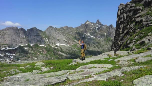 这个人在山上旅行 在山顶上达到目标 这个人在山顶上休息 享受壮丽的风景 — 图库视频影像