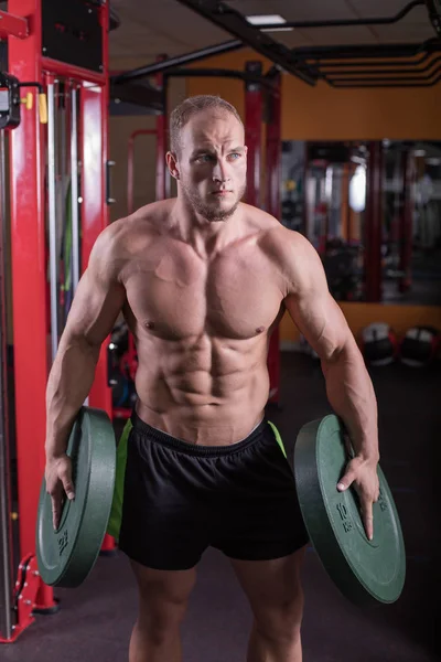 一个男人正在健身房里从事健美运动 提高酒吧和训练他的肌肉 — 图库照片