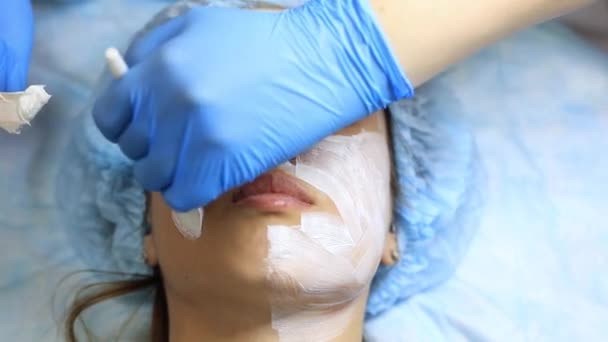 Une jeune et belle fille à la réception d'un cosmétologue. Cosmetologue fait une femme rajeunissant procédures sur la peau du visage — Video