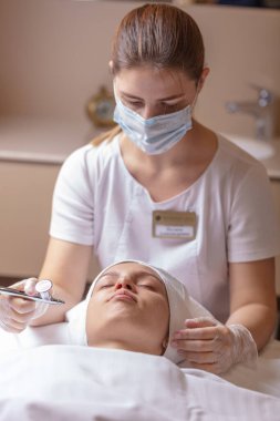 Özel bir aletle yüzünü ıslattım. Temizleme, yumuşatma ve kadın yüzünü nemlendirme.