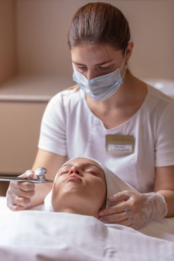 Özel bir aletle yüzünü ıslattım. Temizleme, yumuşatma ve kadın yüzünü nemlendirme.