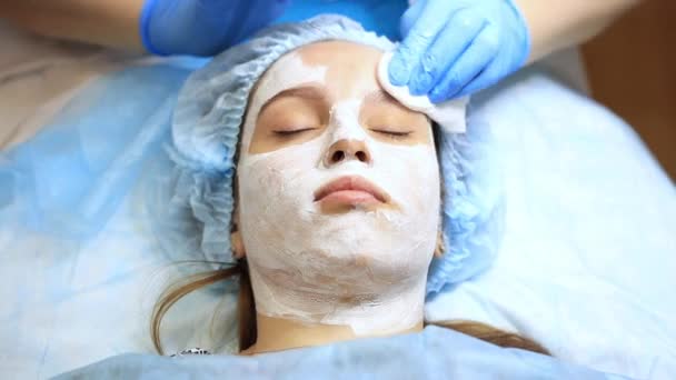 Ein junges und schönes Mädchen beim Empfang eines Kosmetikers. Kosmetologe macht eine Frau verjüngende Eingriffe auf der Haut des Gesichts — Stockvideo
