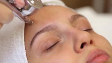 Özel bir aletle yüzünü ıslattım. Temizleme, yumuşatma ve kadın yüzünü nemlendirme.