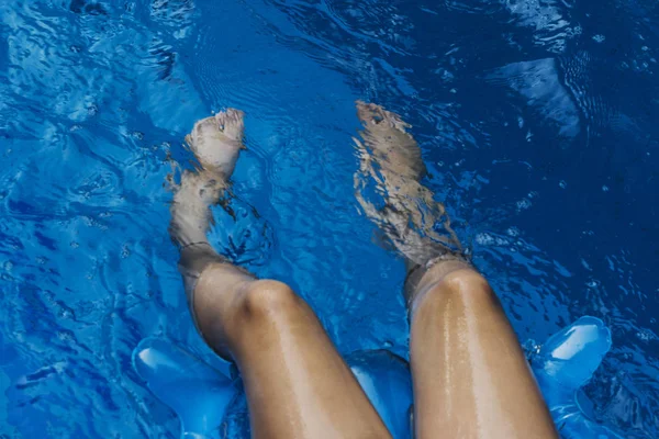 spray, drops in the pool foot of swimming child, selective focus