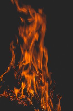 Şöminedeki dallardan gelen koyu renk şenlik ateşi. alev ve kıvılcım.