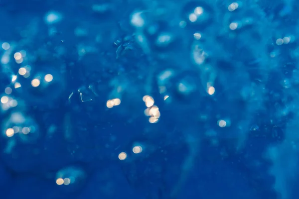 Luz reflejada en el agua con burbujas de aire y bokeh —  Fotos de Stock