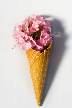 Bir güzel leylak clematis ve pembe pelargonium ve yaprakları ile gül ile Waffle koni