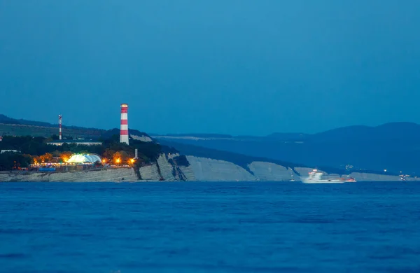 light the beacon at the entrance to the Gelendzhik Bay. Lighthouse at night shines ships in the Black sea.