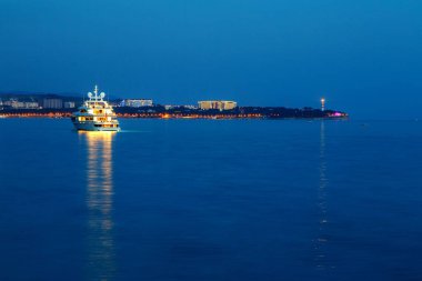 İyi akşamlar. Parlak Gelendzhik deniz feneri arka plan üzerinde Bay Park yat yaktı. Işık güzel Gelendzhik koyunda yansıtılır