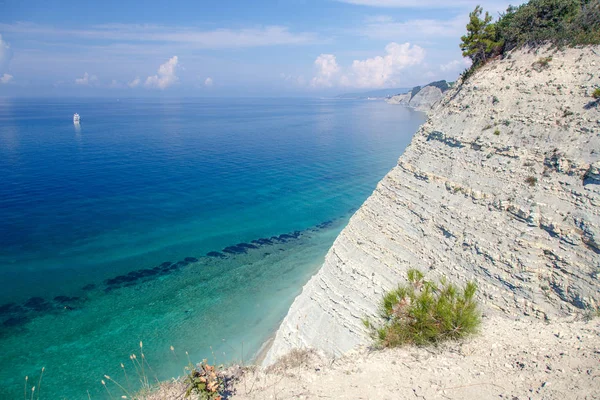 steep steep cliffs, pine trees, yacht in the clear sea, the coast of Gelendzhik, Sosnovka beach, Gelendzhik, Black sea