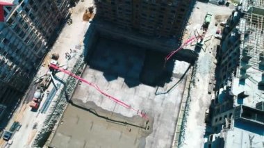 bir evin temeli beton döküm. Bird's-Eye view. İki beton pompa çözüm nerede işçi beton düzleme toprak bir çukura besleme. Beton Mikser içinde taşınır. Etrafında zaten çok katlı evler inşa edilir