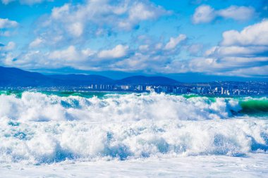 Karadeniz 'de fırtına ve fırtına. Tsemess Körfezi 'nin sularındaki kar beyazı denizden gelen zümrüt fırtınası dalgaları. Novorossiysk ve Kafkas dağları ufukta görünüyor.