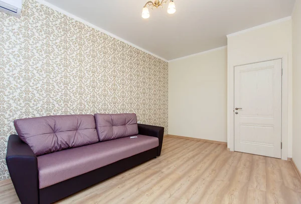 An empty newly renovated room with light Wallpaper, curtains on the Oka and a laminate floor "under the tree". There is a brown sofa against the wall — Stock Photo, Image