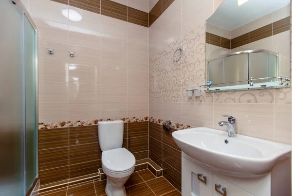 Baño con ducha en la casa nueva. Renovación fresca. Azulejos beige en las paredes y azulejos marrones en el suelo —  Fotos de Stock