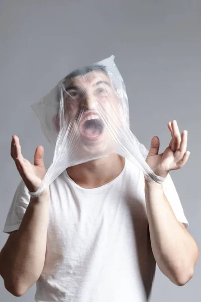 Schreiender und gefesselter Mann, der gegen eine Plastiktüte kämpft. Umfrage — Stockfoto