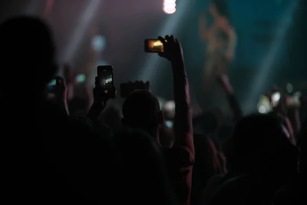 Hand fan with a smartphone shoots a concert