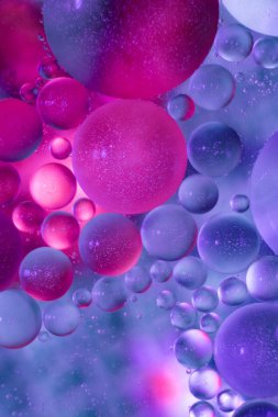 Yağ ile su üzerinde parlak soyut kabarcıklar