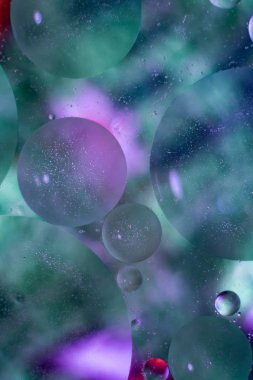 Yağ ile su üzerinde parlak soyut kabarcıklar