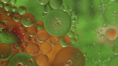 Yağ ile su üzerinde parlak soyut kabarcıklar