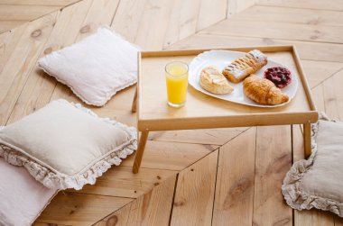 Bir tepsi, yatakta kahvaltı taze sıkılmış meyve suyu ve kruvasan