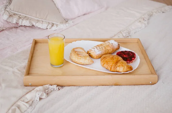 Reggeli Ágyban Egy Tálca Frissen Facsart Gyümölcslé Croissant — Stock Fotó