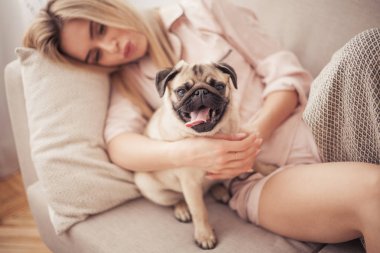Güzel kız onu Pug sarılma ve evde onunla oynuyor