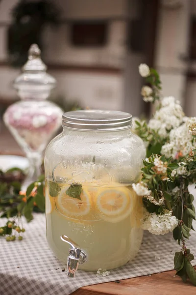 在室外木制桌子上的玻璃瓶里放柠檬水 夏日清爽饮料 图库图片