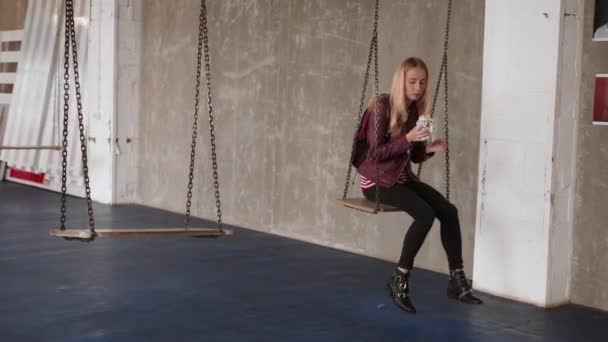 Woman eats, fast food, doner kebab, pita, shawarma. Swing in a seesaw. Loft place — Stock Video