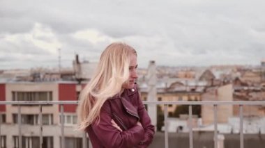 Deri ceket duyumsamak soğuk duran 4k rüzgarda çatıda donmuş kadında