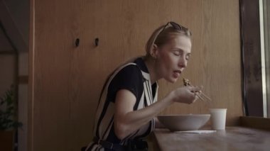 Kafkas kadın nefis erişte yerel bir Çin restoranında çubukla yemek.