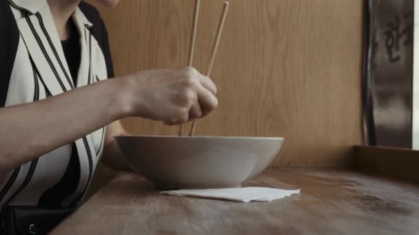 Mujer caucásica comiendo fideos deliciosos en un restaurante chino local con palillos — Vídeos de Stock