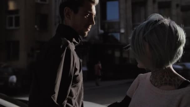 Jeune couple heureux tatouage marcher ensemble dans la ville au coucher du soleil au ralenti 