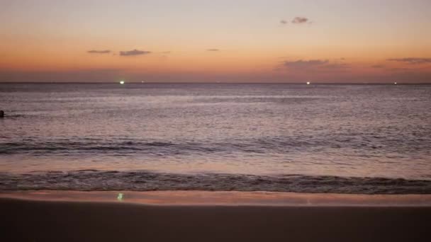 Silhouet van gelukkig kind meisje lopen langs het strand bij zonsondergang. Slow-Motion. Kind wordt uitgevoerd op het strand, werpt spatten — Stockvideo