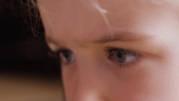 Close-up de olhos de menina assistindo TV com grande interesse — Vídeo de Stock