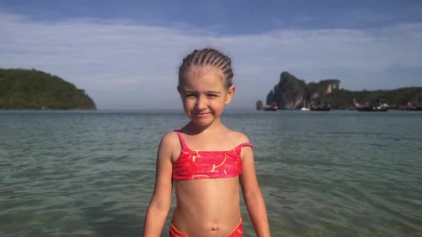 Little girl in the sea. Portrait of adorable kid in swimsuit on her summer tropical holidays in 4K — Stock Video