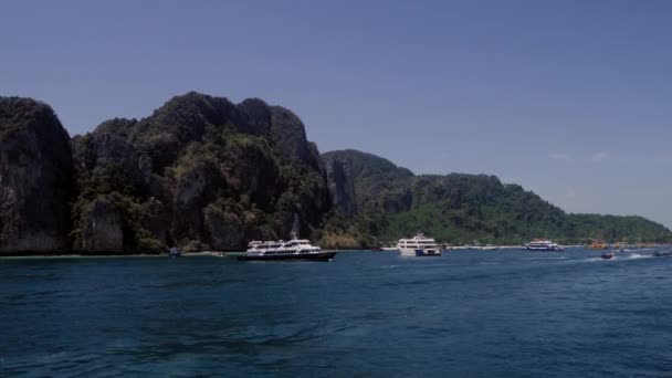Navegación y barcos de motor que se mueven cerca del muelle de la isla koh phi phi en Tailandia. Vídeo de viajes de estilo de vida en 4K — Vídeo de stock
