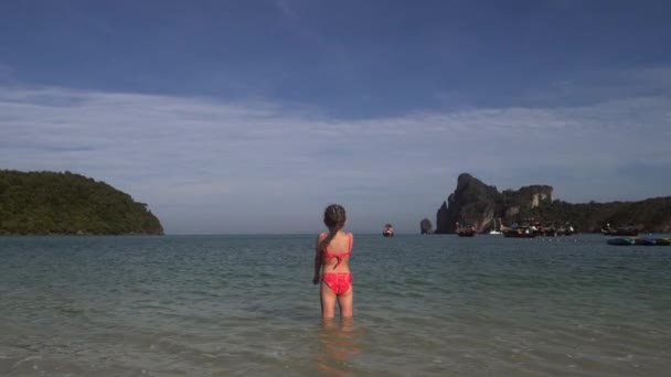 Menina brincando na água na praia — Vídeo de Stock