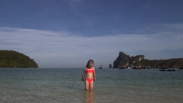 Dívka si hraje ve vodě na pláži — Stock video