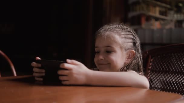 Χαριτωμένο παιδί κορίτσι πρόσωπο πορτρέτο Παρακολουθήστε κινούμενα σχέδια μέσω έξυπνο τηλέφωνο — Αρχείο Βίντεο