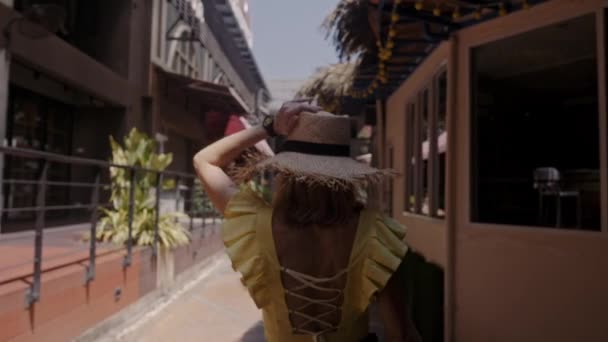 Belle femme en chapeau de paille marche dans la rue. Jouer à la caméra . — Video