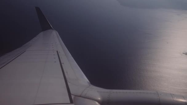 Літак летить над тропічним островом, вид через вікно літака — стокове відео