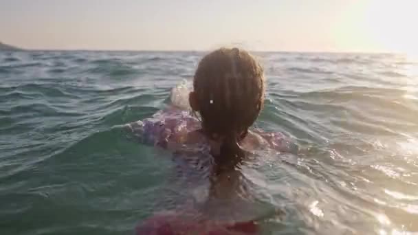 Kleine jonge meisje leren om te zwemmen in de zee — Stockvideo
