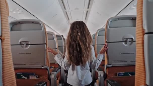 Inuti Airoplane, barn som går i flygplanskabinen, liten söt flicka går gången in i flygplanskabinen — Stockvideo